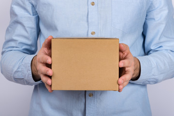 Man holding cardboard box. Delivery service. close up. copy space. mockup.
