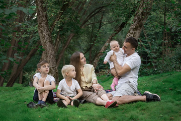 Fototapeta premium Picnic with whole family. Friendly loving family. Parents and three children.