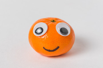 Little tangerine with big Googly eyes and smile. Mandarin character on white background