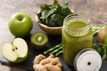 Healthy green smoothie in jar on wooden table	