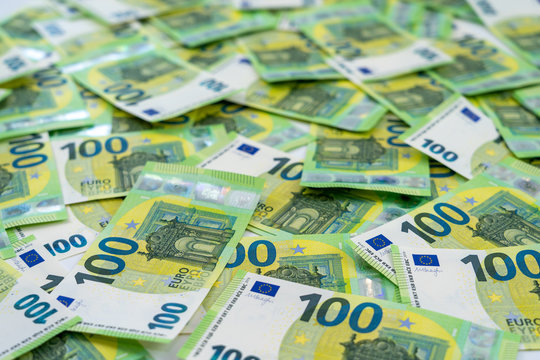 Banknotes of 100 hundred euros are scattered in a chaotic manner. European currency. Side view, close-up. Blank for design, background.