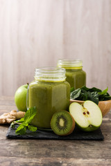 Healthy green smoothie in jar on wooden table	