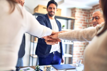 Obraz premium Group of business workers standing with hands together at the office