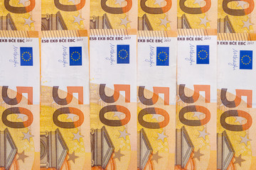 Banknotes of 50 fifty euros lie exactly in two rows. European currency, close-up. Blank for design, background. Vertical layout.