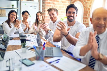 Group of business workers smiling happy and confident. Working together with smile on face looking at the camera applauding at the office