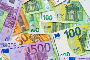 European currency lies on the table. Banknotes five hundred, one hundred, two hundred, fifty euros are scattered in a chaotic manner. Blank for design, background. Close-up. View from above.