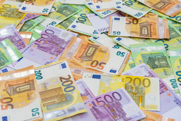 European currency lies on the table. Banknotes one hundred, two hundred, fifty, five hundred euros are scattered in a chaotic manner. Blank for design, background. Side view.