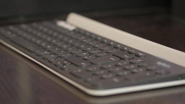 Man's hand repeatedly presses backspace key on wireless keyboard. 
