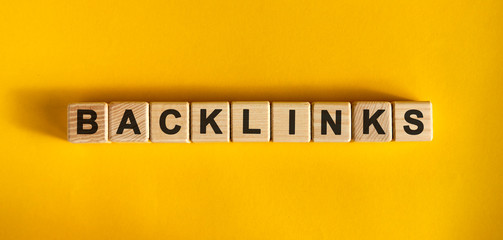 Backlinks word cube on a yellow background. Seo concept.