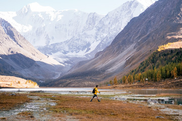 Fototapeta na wymiar Man Traveler with backpack mountaineering in Altai mountain near Ak-Kem lake, Siberia, Russia. Travel Lifestyle concept.