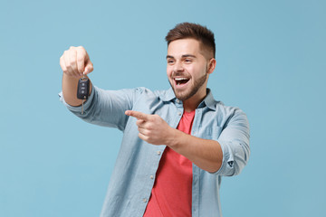 Excited young bearded guy 20s in casual shirt posing isolated on pastel blue wall background studio...