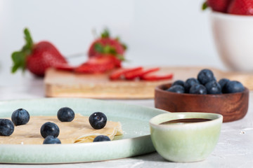 Sweet crepes with chocolate, strawberries and blueberries for Breakfast.