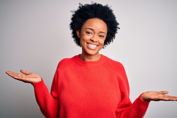 Young beautiful African American afro woman with curly hair wearing red casual sweater smiling showing both hands open palms, presenting and advertising comparison and balance