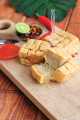 meatball tofu is a traditional snack made from tofu, glutinous rice powder and beef. served in bowl with sauce and green chili. white background. Suitable for in Ramadan food. Selective focus. 