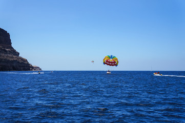 Recreational boat and kite surf off the coast near Puerto Mogán