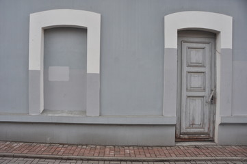 Old Wooden Door and Bricked-Up Window on a Gray Wall
