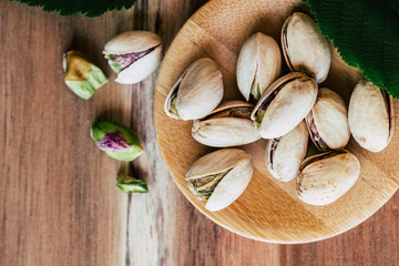 Délicieuses pistaches dans un bol sur la table en bois