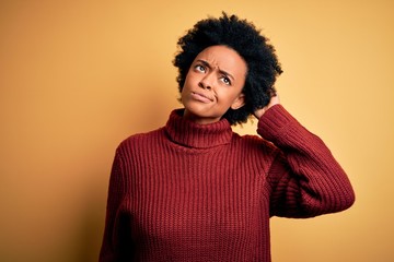 Fototapeta na wymiar Young beautiful African American afro woman with curly hair wearing casual turtleneck sweater confuse and wondering about question. Uncertain with doubt, thinking with hand on head. Pensive concept.