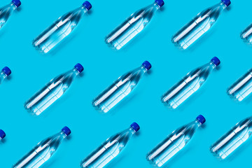 many plastic water bottles on a blue background shot from above