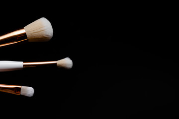Makeup flat lay brushes on black background. Horizontal top view copyspace. Beauty and make up concept