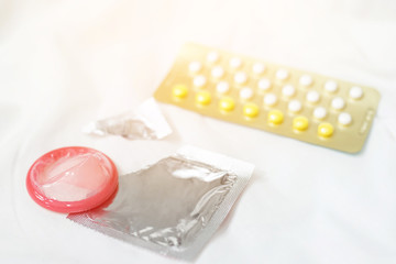 Contraceptive means. pill and condom on the bed. Protection, safe sex. Contraception, concept birth control. Copy space. soft focus.