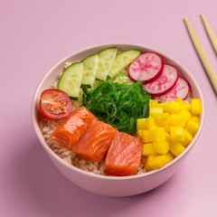 Traditiona Hawaiian red fish poke bowl with rice, radish,cucumber, tomato, and seaweeds. Buddha bowl. Diet food. Flat lay.
