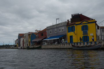 Fototapeta na wymiar cloudy day view of a canal with traditional colorful Moliceiro boats in Aveiro