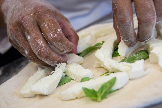 Detail Of The Hands Of A Pizza Chef Maker Works For The Various Stages Of Preparing A Real Italian Pizza Homemade With Yeast Flour And Water.