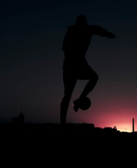 Fototapeta na wymiar one man soccer player playing with ball during sunset silhouette