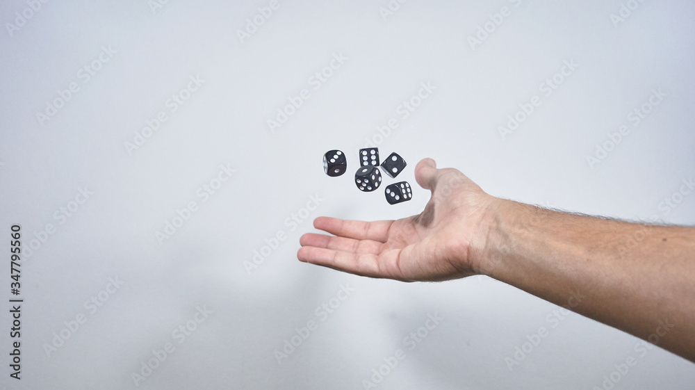 Wall mural hand throwing dice in the air on white background