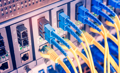 Fiber Optic cables connected to optic ports and UTP and Network cables connected to ethernet ports