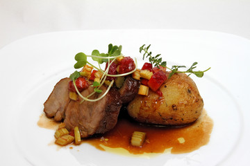 Roast meat with baked potato, strawberries and vegetables