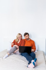 Young adult couple using laptop together at home