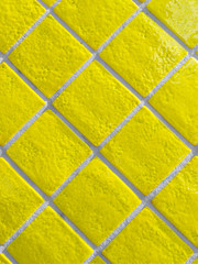 Yellow tiled wall pattern with textured glazed surface