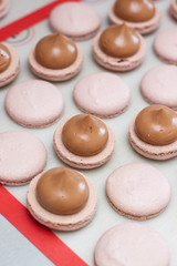 Making chocolate macaroons. Filling shells with chocolate ganache. Selective focus.