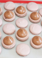 Fototapeta premium Making chocolate macaroons. Filling shells with chocolate ganache. Selective focus.