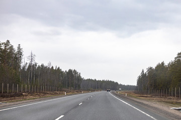 road with white dividing strip on the background of beautiful sky with clouds