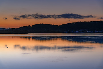 Obraz na płótnie Canvas Smooth Sunrise with Light Cloud over the Bay