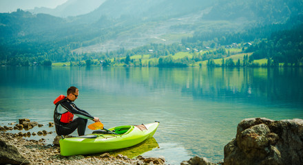 Man Relaxing By Lake After Long Day Of Canoeing.