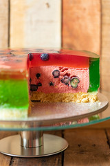 Torte als Melone auf einem Tisch aus Holz mit Götterspeise und Creme