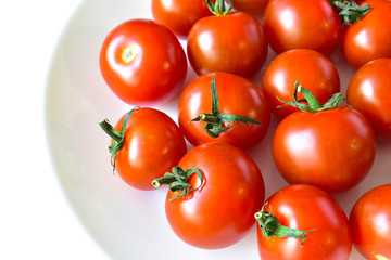 Small red cherry tomatoes on a plate in a group