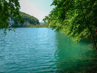 Small lake  in the green summer forest with turquoise water