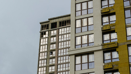 Obraz premium Modern apartment buildings on a gray day with a dramatic sky. Facade of a modern apartment building.