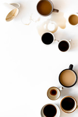 Different cups of coffee on white table top-down space for text
