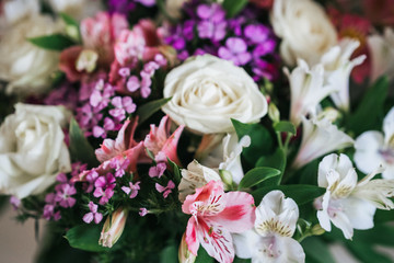A bright, luxurious bouquet of colorful alstromeria and white roses. Photo with blurred background.