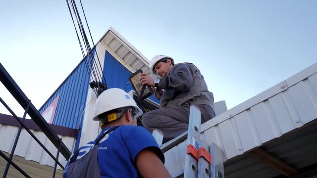 Technician makes repairs in the technical box of the Internet provider