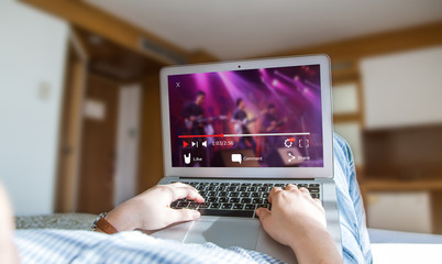 Online video streaming concept.Female watching music video via laptop at home