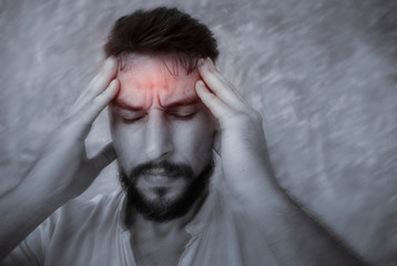A man suffering headache from a painful head pain  and looking tired, worried and stressful