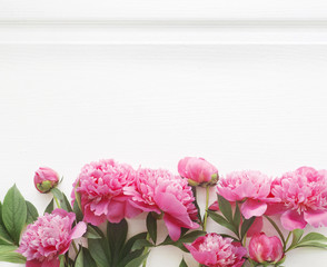 Top view of peony flower border over wooden table. Empty mockup, ready for text place. Minimal interior design, flatlay image.