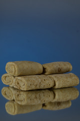 Semi-finished products. Filled Frozen Pancakes. On a mirror background. Isolates.